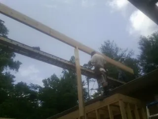 Carpenter setting a ridge beam over a new addition frame — Ice Dam Removal by Roofing Brothers in Westerville