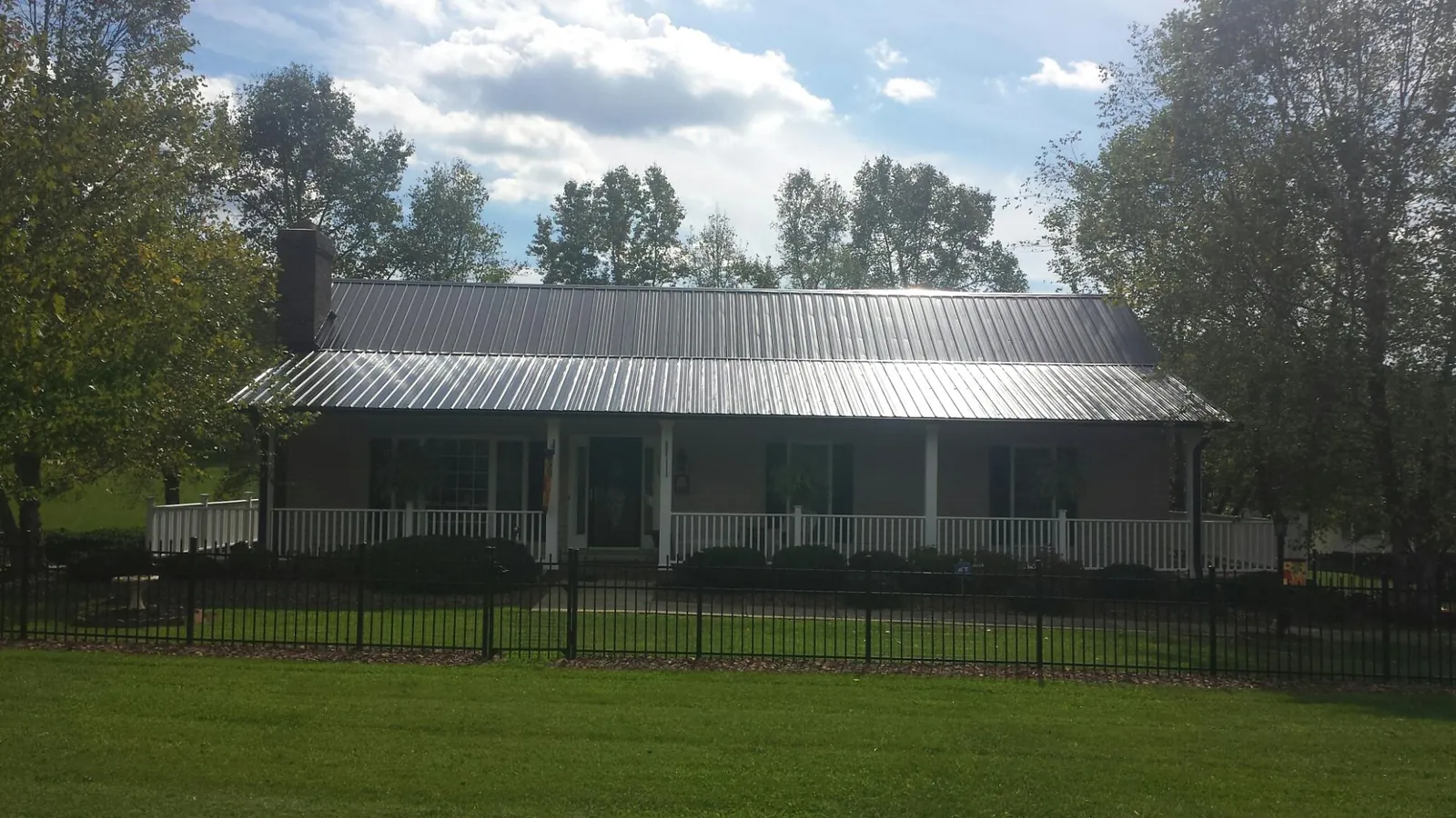 Gray metal roof on a brick ranch with a full width front porch — Gutter Guard Installation work by our crew in Westerville